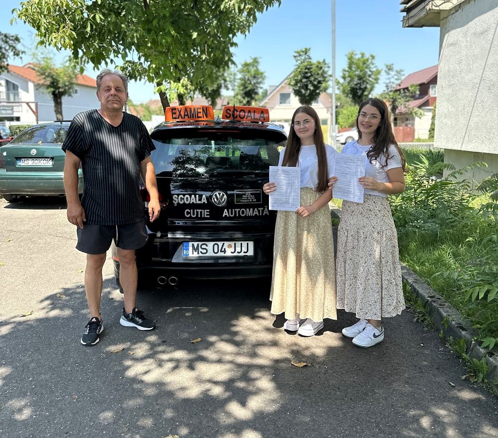 Sikeres vizsgázók az iskola automata váltós Golfja mellett, tetején EXAMEN táblával